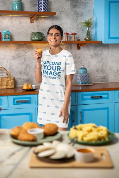 T-Shirt Dress Mockup Featuring a Cheerful Woman Holding a Snack in a Kitchen m41144