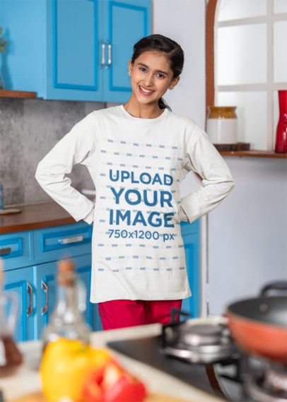 Bella Canvas Long-Sleeve Tee Mockup of a Smiling Teenage Girl Standing in a Blue Kitchen
