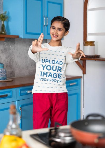 Bella Canvas Long-Sleeve Tee Mockup Featuring a Happy Teenage Girl Posing in a Kitchen