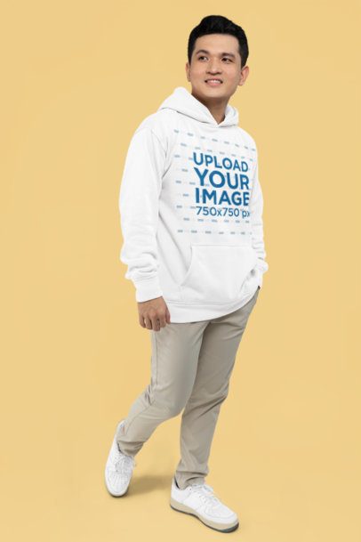 Mockup Featuring a Man Posing in a Pullover Hoodie Against a Yellow Background