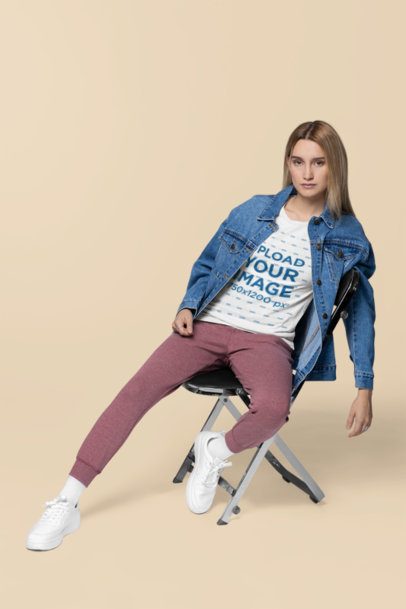 Bella Canvas T-Shirt Mockup of a Serious Woman With a Denim Jacket Sitting on a Chair m40833