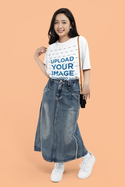 Mockup of a Smiling Woman Wearing a Round-Neck Tee and Denim Garments in a Studio