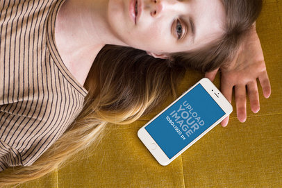 Mockup of an iPhone Lying Next to a Woman on a Mustard Cloth a21501