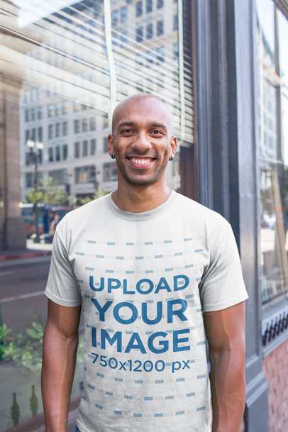 Mockup of a Happy Man Wearing a T-Shirt Outside a Store