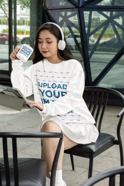 Sweatshirt Mockup of a Woman with Headphones Holding an 11 oz Coffee Mug