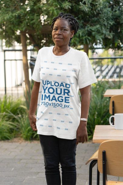 Bella Canvas Round-Neck Tee Mockup of an Elderly Woman Standing by a Restaurant Table 