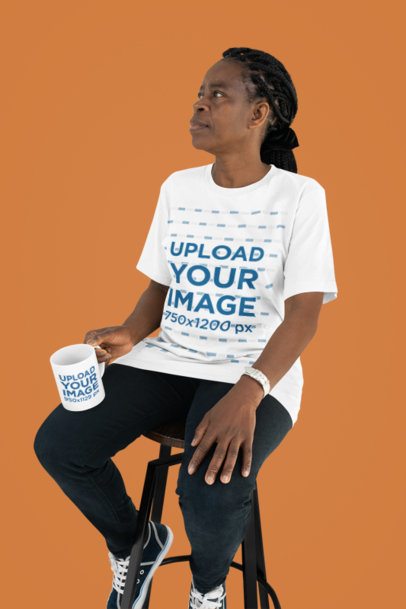 Bella Canvas Tee Mockup Featuring an Elder Woman Sitting on a Chair With a Coffee Mug m51485