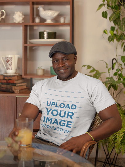 T-Shirt Mockup of a Man with a Beret Having an Orange Juice