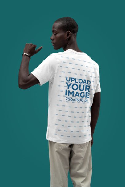 Back-View Mockup of a Man Pointing at His Bella Canvas T-Shirt in a Studio