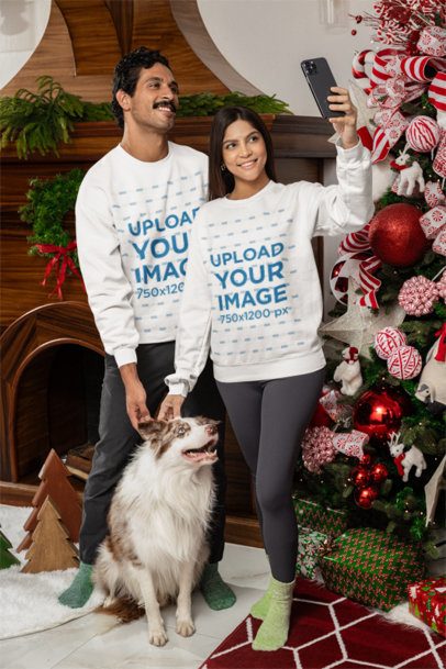 Sweatshirt Mockup of a Happy Couple and Their Pet in a Christmas-Decorated Room