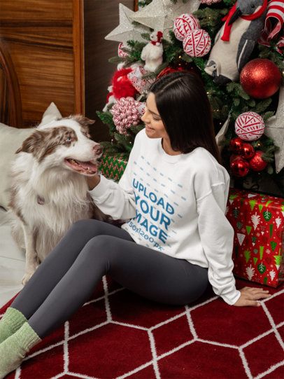 Xmas-Themed Mockup of a Woman Wearing a Gildan Sweatshirt While Petting Her Dog