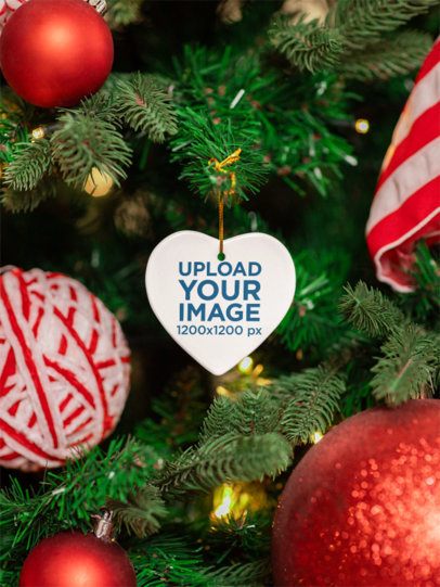 Xmas-Themed Mockup of a Ceramic Heart-Shaped Ornament Hanging on a Tree