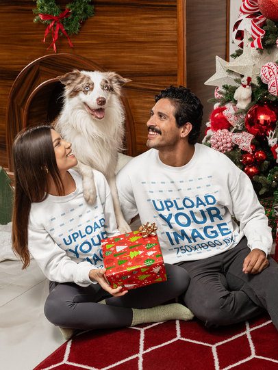 Xmas-Themed Mockup of a Smiling Couple Wearing Gildan Sweatshirts Next to Their Dog