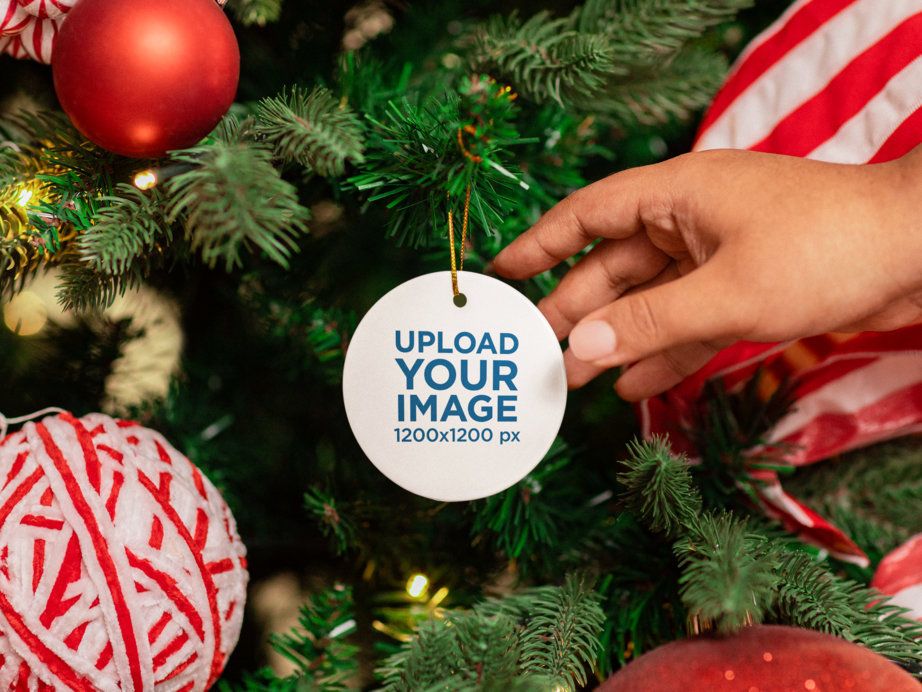 Mockup of a Person Putting a Rounded Ceramic Ornament on a Christmas Tree