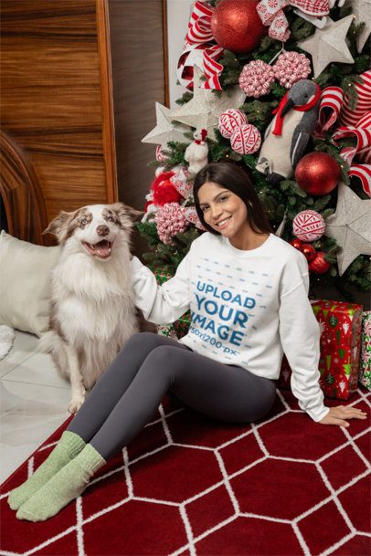 Gildan Sweatshirt Mockup of a Woman Sitting with Her Dog Next to a Christmas Tree