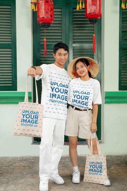 Lunar New Year Mockup of a Joyful Couple Wearing Oversized Tees and Tote Bags m52229