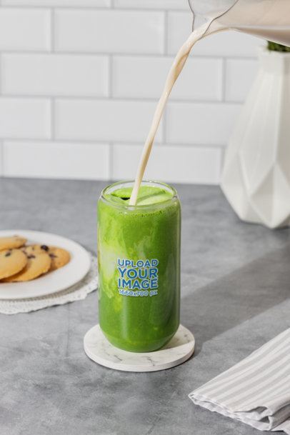 Mockup of a 16 Oz Can Glass Filled With Match Tea in a Kitchen Table m52442
