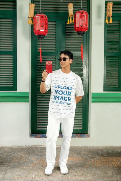 Oversized T-Shirt Mockup of a Man Posing Against a Door With Lunar New Year Decorations m52222