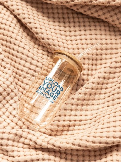 Mockup of an Empty Glass Can Lying on a Cozy Blanket m52438