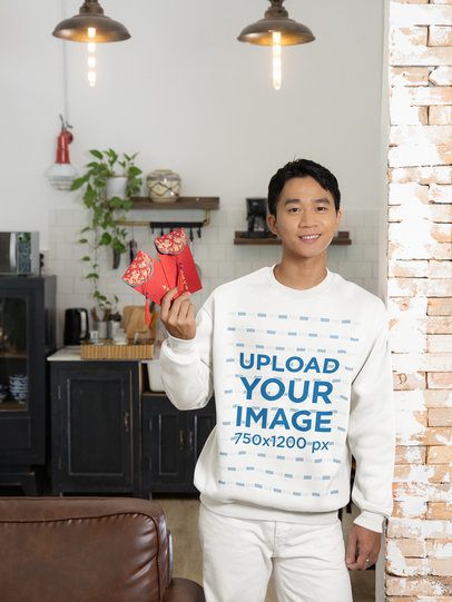 Sweatshirt Mockup Featuring a Man Holding Chinese New Year Envelopes at Home m52242