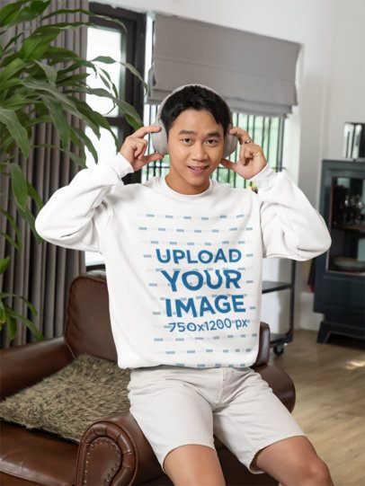 Rounded-Neck Sweatshirt Mockup of a Man Listening to Music at Home m52243