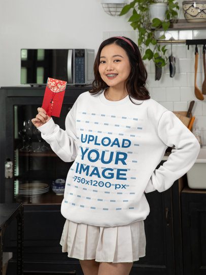 Sweatshirt Mockup of a Woman with a Red Envelope Celebrating the Chinese New Year at Home m52253