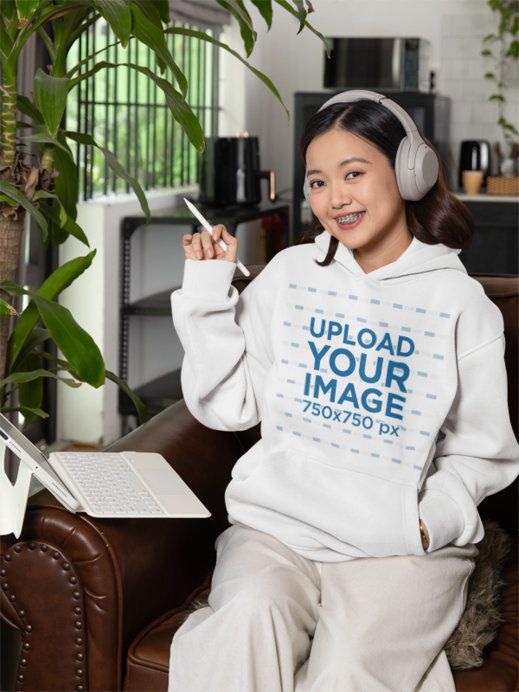 Pullover Hoodie Mockup of a Creative Woman Working on Her Tablet at Home