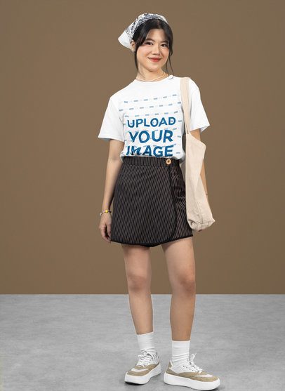 Mockup of a Smiling Teenage Girl Wearing a Rounded-Neck Tee in a Studio