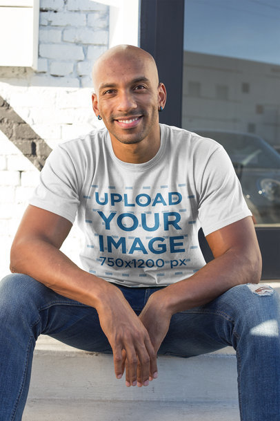 T-Shirt Mockup of a Happy Man Sitting on a Stairway