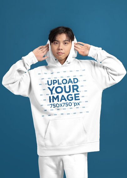 Mockup of a Teenage Boy Wearing a Pullover Hoodie in a Studio with a Solid Background m51436