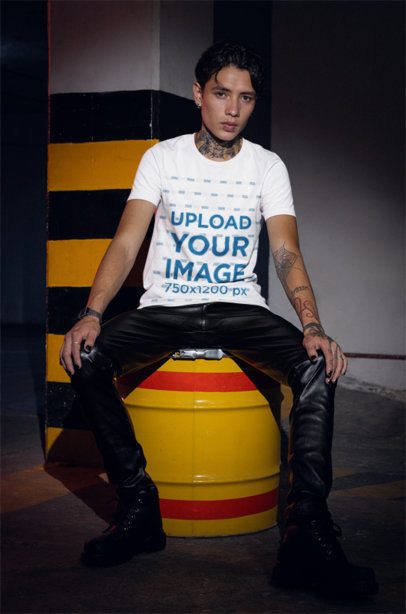 Grunge-Styled Mockup of a Tattooed Man in a Bella Canvas T-Shirt Posing in a Parking Lot