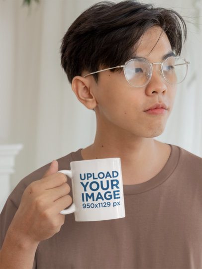 Mockup of a Teenage Boy With Glasses Holding an 11 Oz Coffee Mug