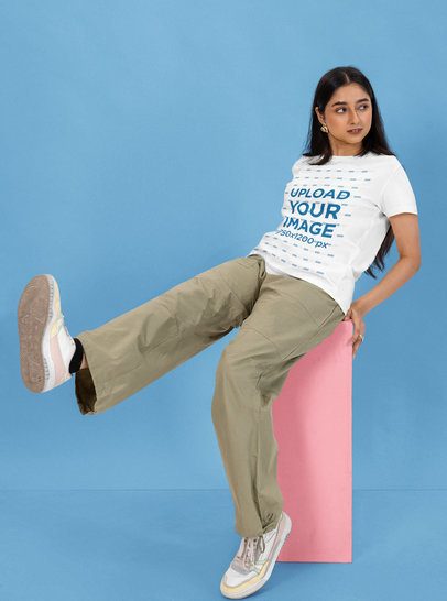 Round-Neck Tee Mockup Featuring a Woman Sitting on a Colorful Cube