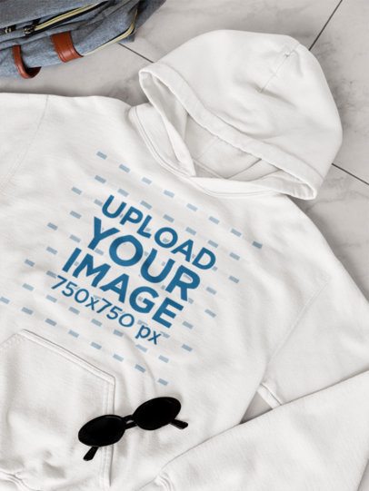 Ouftit-Themed Mockup Featuring a Gildan Pullover Hoodie Lying on the Floor With a Pair of Sunglasses m52006