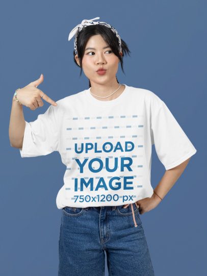 Oversized Mockup Featuring a Woman Pointing at Her Round-Neck T-Shirt in a Studio