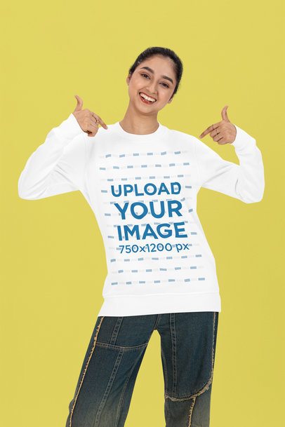 Bella Canvas Long-Sleeve Tee Mockup of a Happy Woman Pointing at Her Garment in a Studio