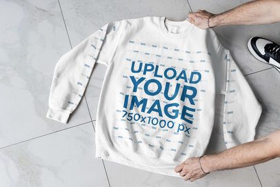 Mockup of a Man Putting a Gildan Sweatshirt Over the Floor m52004