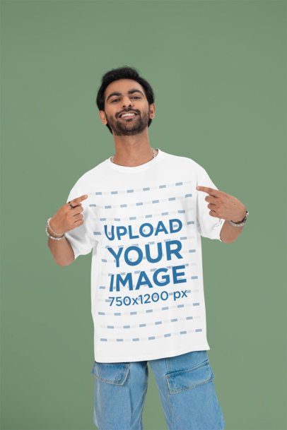 Mockup of a Cheerful Man Pointing at His Oversized Round-Neck T-Shirt in a Studio