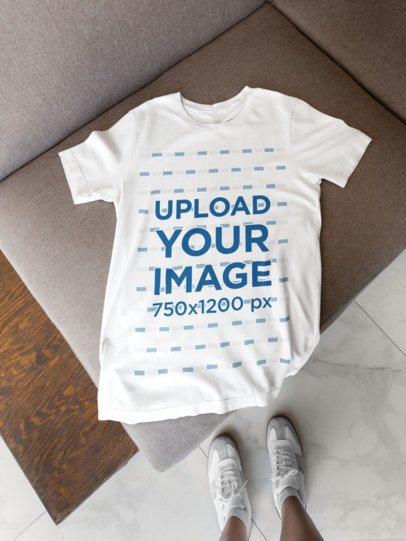 Mockup of a Bella Canvas T-Shirt Lying on a Couch Featuring a Woman's Sneakers m52028