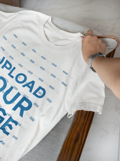 Mockup of a Woman Putting a Bella Canvas T-Shirt Over a Chair