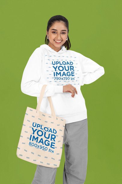 Pullover Hoodie Mockup of a Joyful Woman Carrying a Sublimated Tote Bag in a Studio m53094