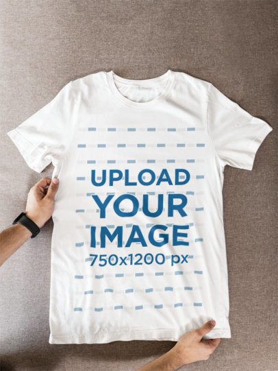 Mockup of a Bella Canvas T-Shirt Lying on a Couch Featuring a Man's Hands