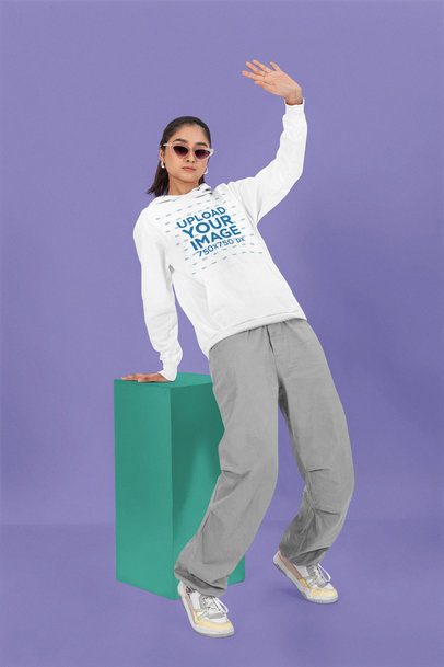 Pullover Hoodie Mockup Featuring a Woman Striking a Pose in a Studio With a Colorful Background m53090
