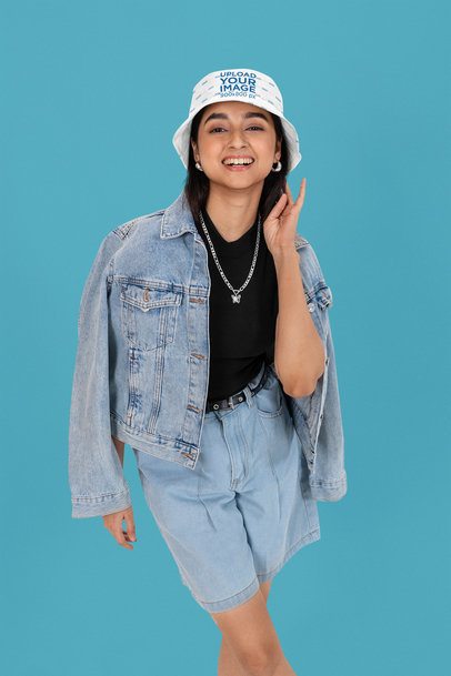 Sublimated Bucket Hat Mockup Featuring a Happy Woman Posing in a Studio With a Denim Outfit