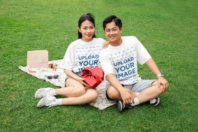 Oversized T-Shirt Mockup Featuring a Smiling Woman and a Man Sitting in the Park for a Valentine's Day Picnic