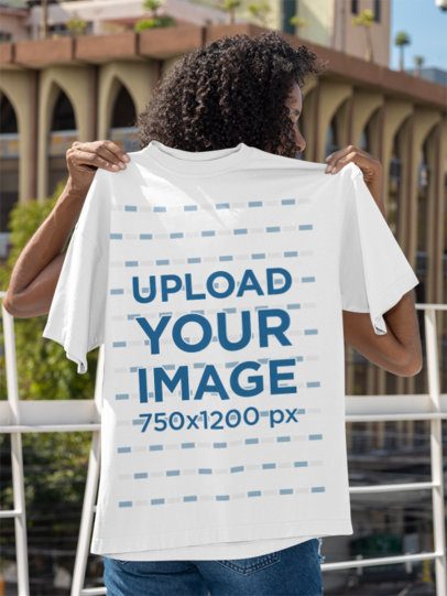 Mockup of a Woman Holding an Oversized T-Shirt on Her Back