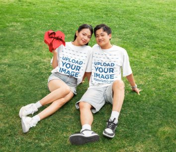 Oversized T-Shirt Mockup Featuring a Smiling Couple With a Valentine's Day Gift Posing in the Park