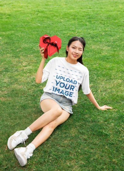 Oversized Tee Mockup Featuring a Woman Winking With a Valentine's Day Present