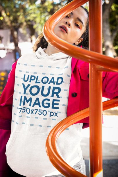 Comfort Colors Hoodie Mockup Featuring a Woman Posing Behind a Playground Game m53354