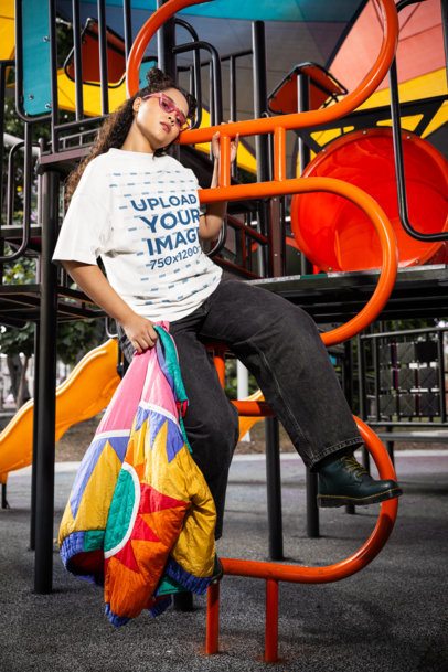 Oversized T-Shirt Mockup Featuring a Woman Posing on a Playground's Game